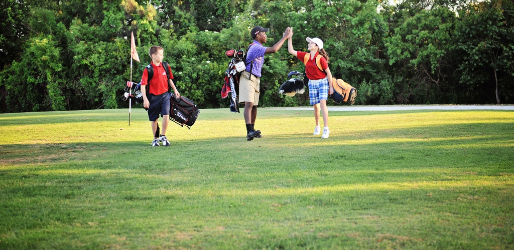 kids on golf course high fiving and having fun in their activity